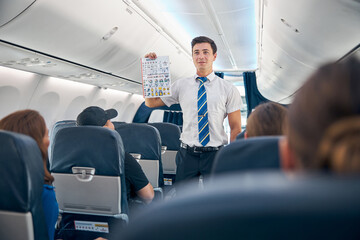 Handsome man holding safety information list to flight take off