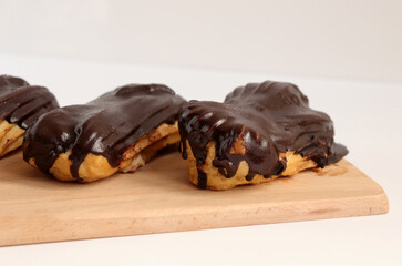Chocolate eclair on wooden desk food photography. Bekery, cake , choco, pie, confectionary, cream....