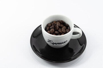 A cup of espresso filled with coffee beans