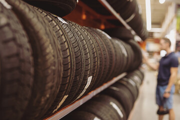 Unrecognizable man chooses car tires on showcase in a mall © antgor