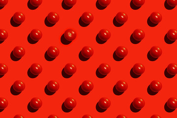 Seamless pattern with tomatos and one other tomato on red background, top view.