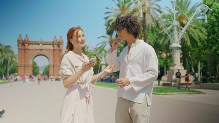 Closeup tourist couple searching direction with phone. Happy couple checking way