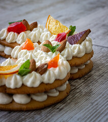 Creamy fruit cake with white filling with orange chips, dried fruits, decorated with mint