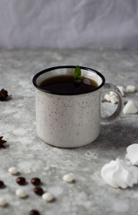 a white mug stands on a white background surrounded by sweets, candies and cookies