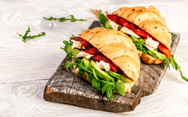 Top view of tasty freshly baked croissants with soft cheese and fresh strawberries