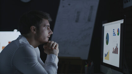 Yawning business man working late in night office.