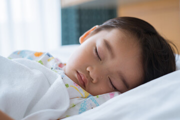 Asian cute little boy is sleeping on the sickbed and the face with tears in the patient room in hospital. Healthcare medical and people concept.