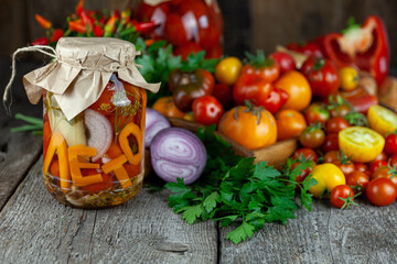 Preservation of the autumn harvest of vegetables. Glass jar with pickled tomatoes. Vegetable food. Tomato of different varieties. The word Summer in Russian letters in a can with conservation.