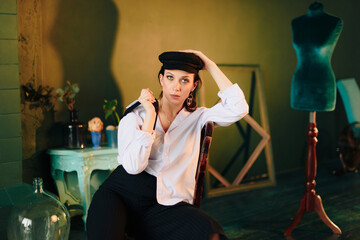 Portrait of a beautiful young woman in a white shirt and black pants in the Studio