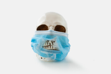 Human skull wearing blue surgical mask ripped and torn around the mouth, exposing teeth, on white background