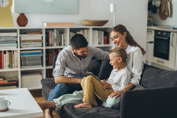 cute young family using tablet together at home