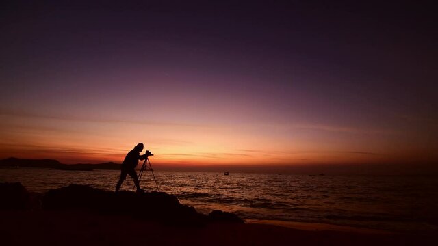 Silhouette photographer take photo on the beach at sunset time.