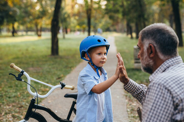 boy giving high five to his grandfather