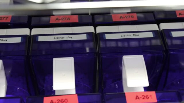 Blue plastic pill storage containers on shelf, panning down shot, close up