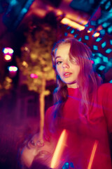 Beautiful. Cinematic portrait of stylish young woman in neon lighted room. Bright neoned colors. Caucasian model, musician outdoors. Youth culture in party, festival style and music concept.