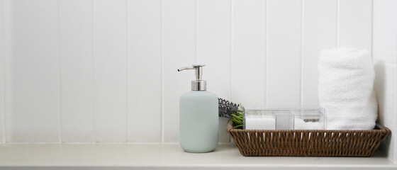 Copy space of minimal bathroom soap dispenser and spa towel on white counter.