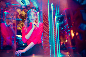 Young forever. Cinematic portrait of stylish young woman in neon lighted room. Bright neoned...