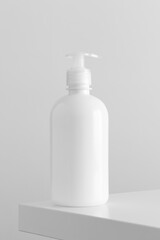 Fototapeta na wymiar White cosmetic liquid soap dispenser bottle mockup on a white table.