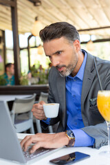 Handsome businessman working on his laptop in the restaurant