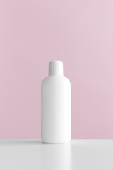 White cosmetic bottle mockup with pink background.