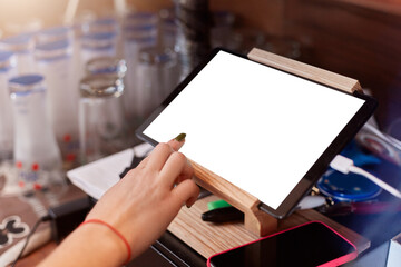 Close up of barista finger with manicure scrolling tablet pc at cafe, plane table with white blank screen, faceless waiter working with online orders, using map case.