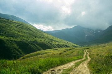 the road leading to the top of the mountain and green hills
