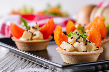 delicious snack tartlets on rustic wooden background