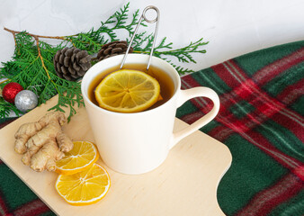 Drinks for Christmas, Thanksgiving. Tea with lemon and ginger. Autumn, winter drink, hot tea, mulled wine. Christmas tree branches, a cozy blanket. On a white marble table close-up.