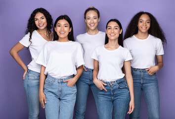 Obraz premium Group Of Happy Mixed Women Hugging Standing Over Purple Background