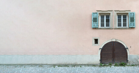 Altes Holztor darüber schöne alte Fenster umrahmt von grünen Fensterläden, rosa Hausfassade,...