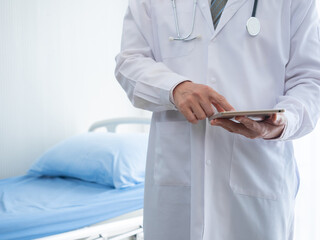 Specialist doctor holding tablet device to check treatment plan and life insurance after use stethoscope listening patient heartbeat on bed in sickness room at hospital