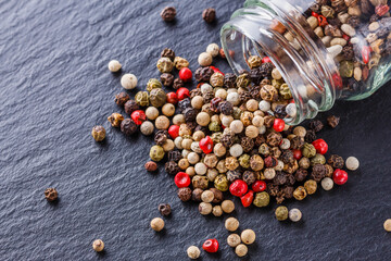mix of peppercorns on a dark stone background