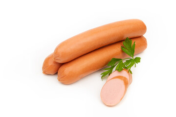 Raw sausages lie in a group on a white background and are decorated with parsley leaves.