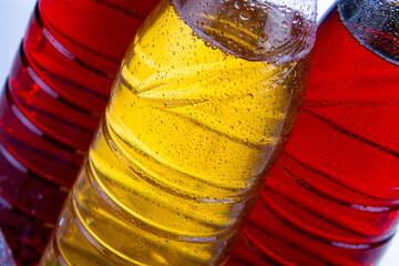 Three bottles with ice tea, with water drops, close up