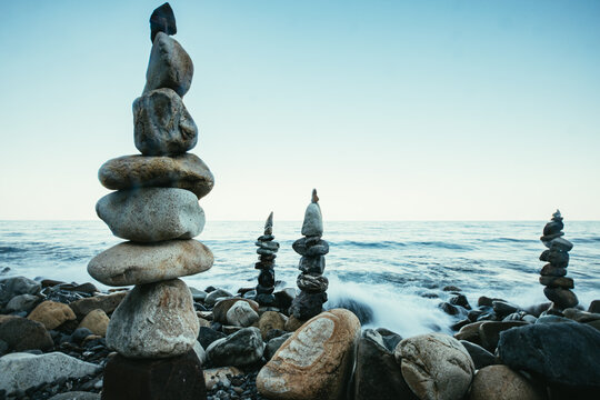 Zen style balanced stones on beach. Rock sculpture stone stacking. A stone pyramid on sea shore.