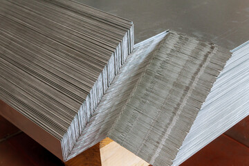 Sheet metal products are stacked on a pallet after a bending process.