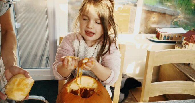 Young girl carving a pumpkin Jack O' Lantern for Halloween decoration