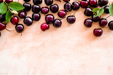 Layout of sweet cherries with leaves, top view, copy space