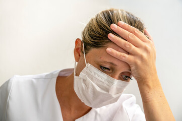 Portrait d'une jeune femme fatiguée du personnel médical portant un masque 