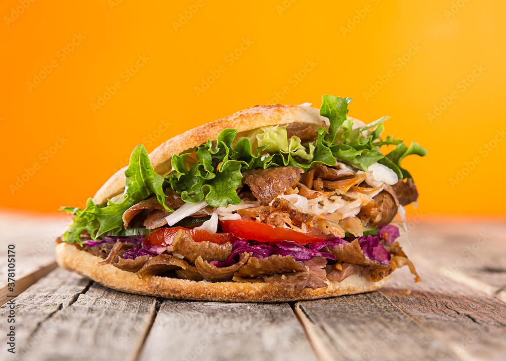 Wall mural turkish doner kebab sandwich on wooden background, close-up.