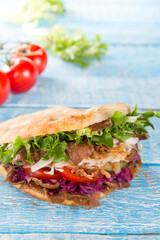 Turkish Doner Kebab Sandwich on wooden background, close-up.