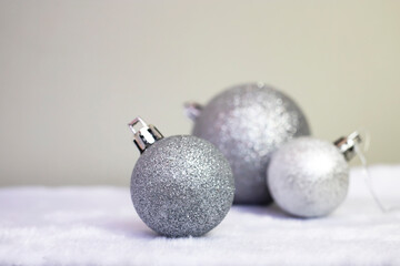 Christmas background. Christmas balls of silver color on a gray background. Space for text, side view.