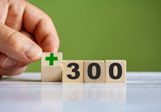 hand turn wooden block with plus sign and set text "+300"