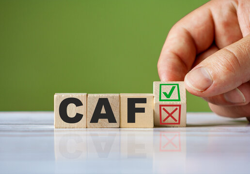 hand turn wooden block with red reject X and green confirm tick as change concept of CAF. Word CAF conceptual symbol.