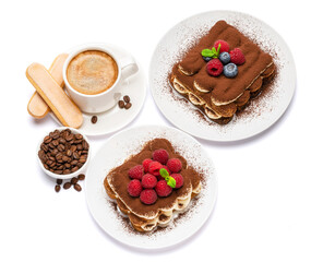 two portions of Classic tiramisu dessert with raspberries and blueberries and cup of fersh hot espreso coffee isolated on white