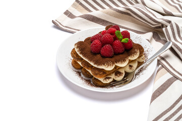 portion of Classic tiramisu dessert with raspberries on ceramic plate isolated on white background with clipping path