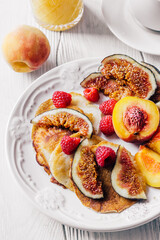 Breakfast a cup of coffee, orange juice and a plate with figs, raspberries and peaches
