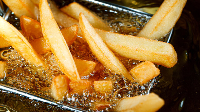 Cooking french fries in the deep fryer, crispy fries, Junk food concept