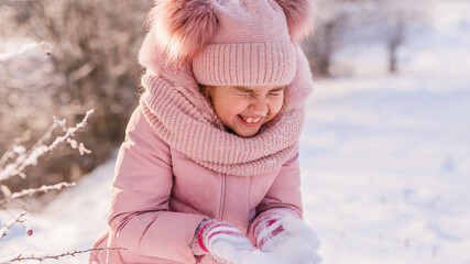 Little girl plays in the winter forest