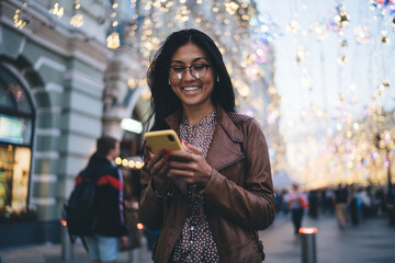 Happy millennial blogger enjoying mobile networking during travel vacations for visiting new...